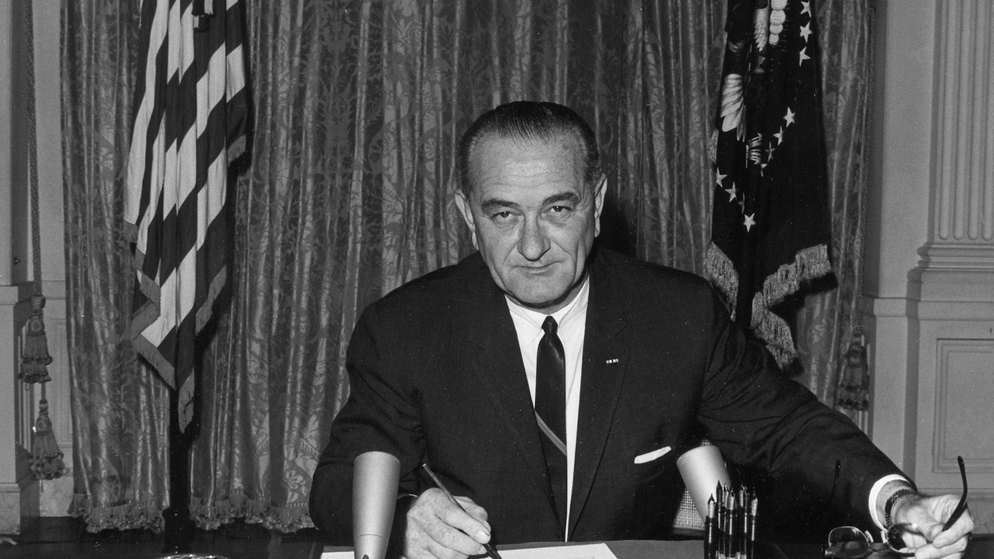 President Lyndon B. Johnson signing the Gulf of Tonkin Resolution in the White House East Room, August 10, 1964